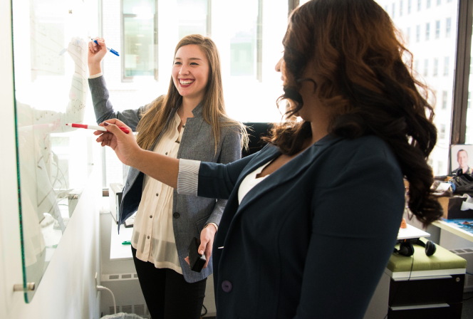 Two women in front of dry erase board 1181533